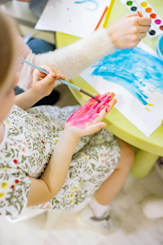 a couple of kids that are sitting at a table, inspired by Helen Frankenthaler, pexels, a hand, square, pink and blue colour, playing