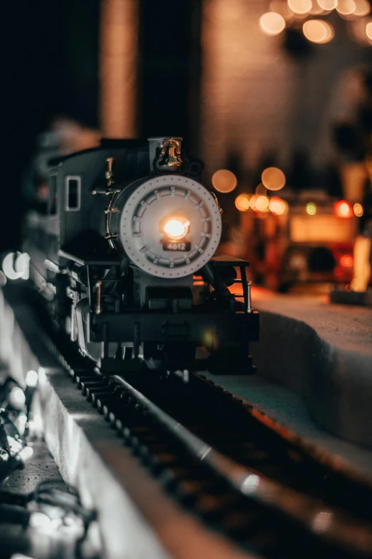 a close up of a toy train on a track, by Sam Black, unsplash contest winner, figuration libre, warm glow from the lights, big engine, replica model, built on a small