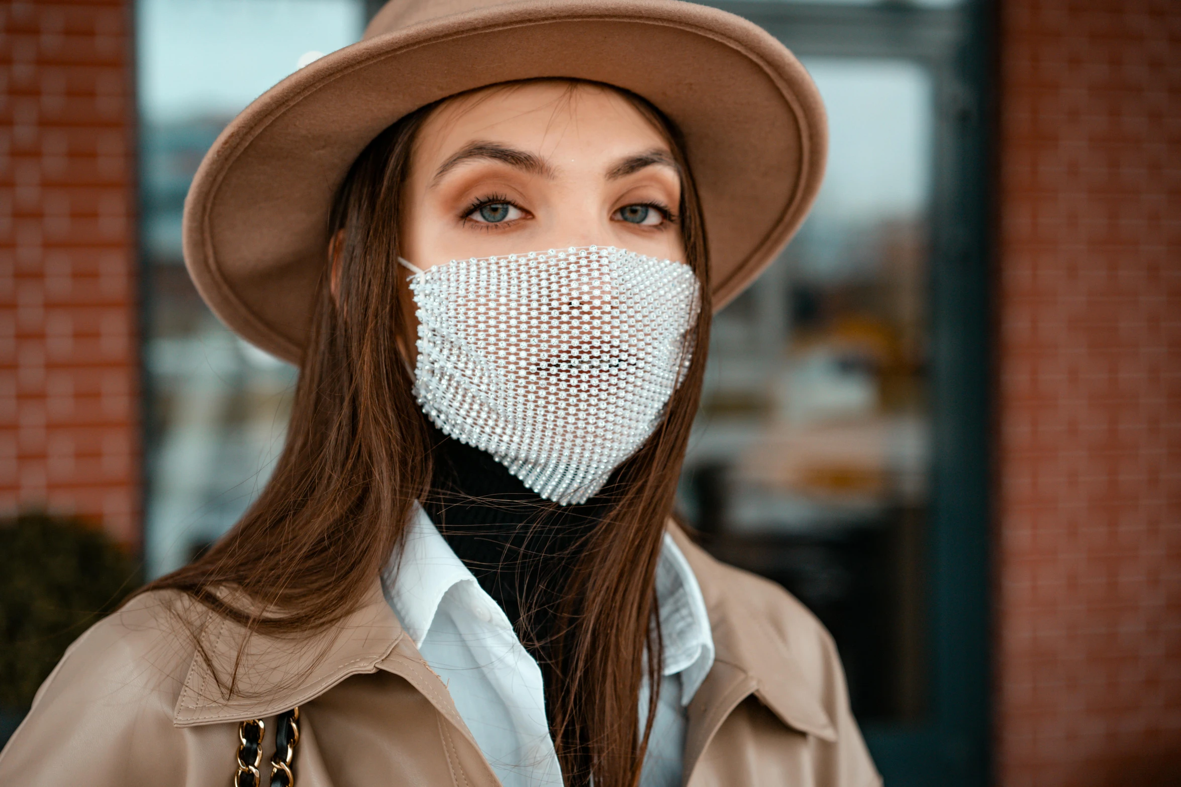 a woman wearing a face mask in front of a building, trending on pexels, renaissance, white pearlescent, caracter with brown hat, chainmail, handsome girl