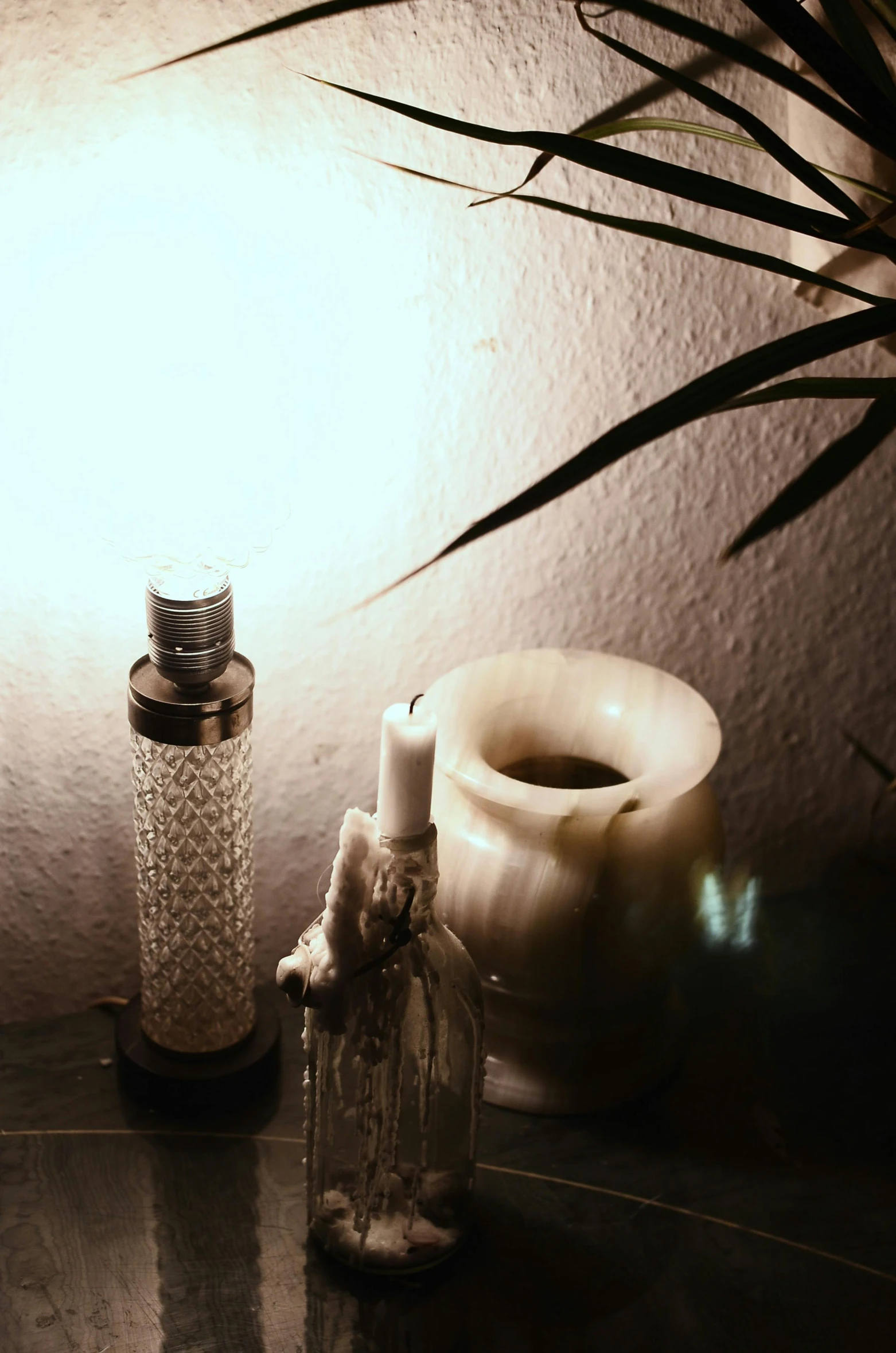 a couple of bottles sitting on top of a table, a still life, inspired by Elsa Bleda, light and space, nightlight, product display photograph, low quality photograph, candle