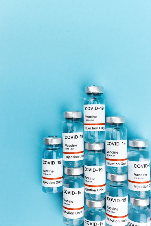 a pile of vials sitting on top of a blue surface, covid, thumbnail, medical labels, abcdefghijklmnopqrstuvwxyz