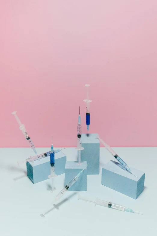 a bunch of syops sitting on top of a table, by Sebastian Vrancx, pexels contest winner, conceptual art, syringes, blue and pink shift, product design shot, four-dimensional