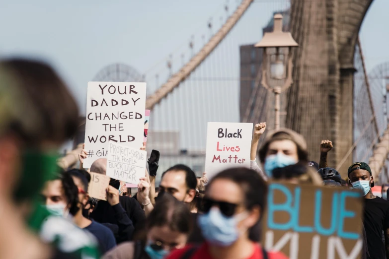 a group of people holding signs that read your daddy changed the world, a picture, by Matija Jama, pexels, black arts movement, bridges, 9 / 1 1, a photo of a man, blue-black