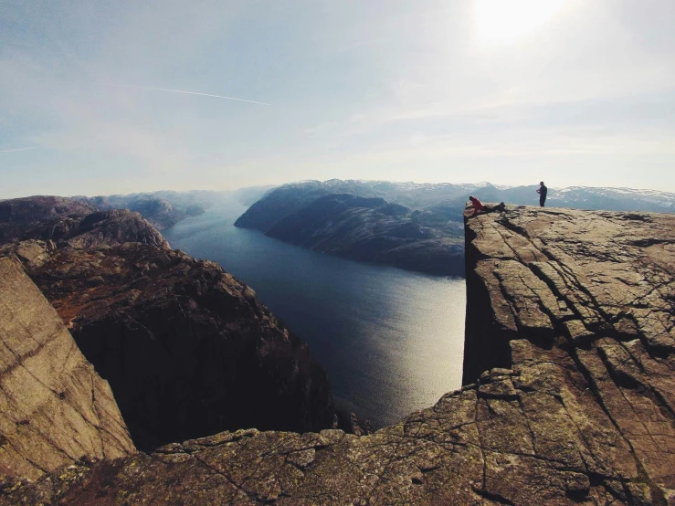 a couple of people standing on top of a cliff, by Jesper Knudsen, pexels contest winner, snapchat photo, ultrawide lens”