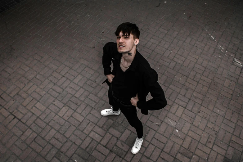 a man standing on top of a brick sidewalk, an album cover, inspired by Kristian Kreković, pexels contest winner, bauhaus, portrait big dark punk, androgynous vampire, intimidating pose, intricat