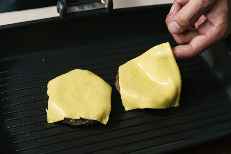 a person putting cheese on a hamburger on a grill, silicone skin, momoshiki ōtsutsuki, angled, glossy yellow