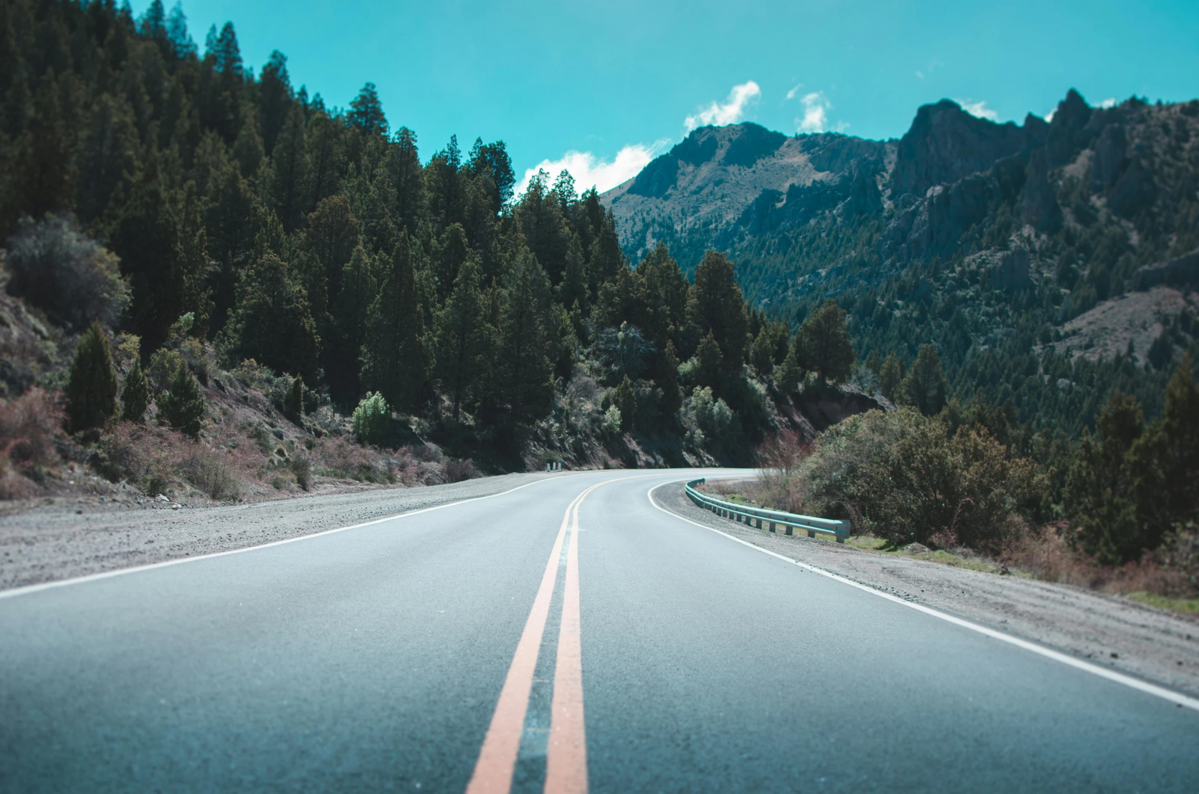 an empty road with a mountain in the background, unsplash, visual art, 2 5 6 x 2 5 6 pixels, dashcam footage, street of teal stone, 🚿🗝📝