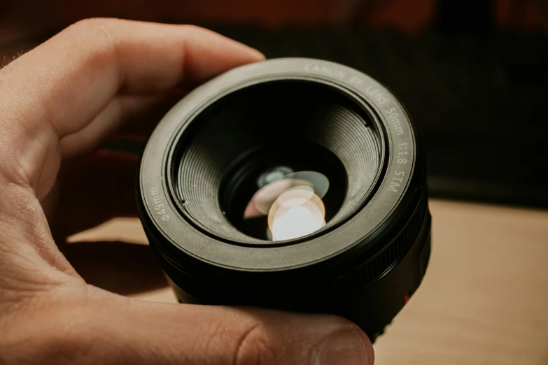 a close up of a person holding a camera lens, by Matthias Stom, pexels contest winner, photorealism, 2 4 mm leica anamorphic lens, lighting her with a rim light, 35mm of a very cute, 4 5 mm. photorealistic