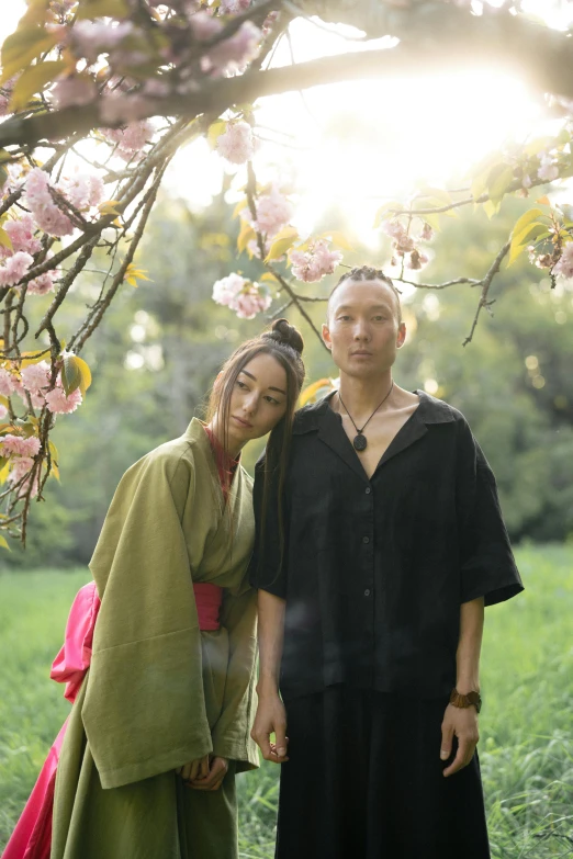 a man and a woman standing under a tree, inspired by Itō Shinsui, unsplash, polaroid fashion photography, silk robes, ethnicity : japanese, concert