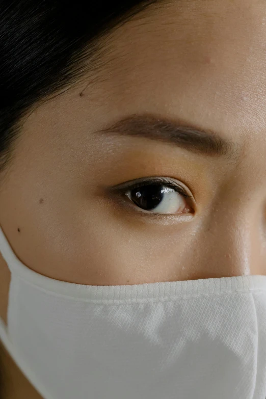 a close up of a woman wearing a face mask, trending on pexels, hyperrealism, jimin\'s right eyelid swollen, portrait of a female pathologist, looking towards the camera, eye - level medium - angle shot