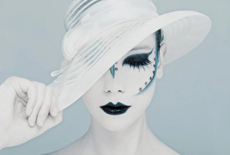 a close up of a person wearing a hat, an album cover, inspired by hajime sorayama, aestheticism, white cyan, kabuki makeup, fashion photograhy