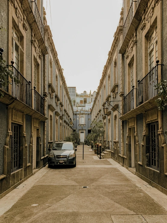 a car is parked on the side of a narrow street, by Pablo Rey, pexels contest winner, neoclassicism, full building, square, gif, low quality photo