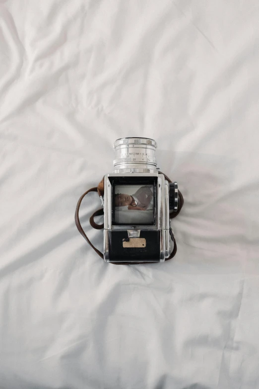 a close up of a camera on a bed, inspired by Vivian Maier, unsplash contest winner, visual art, unsplash transparent, hasselblad medium format, antique photography, on a pale background