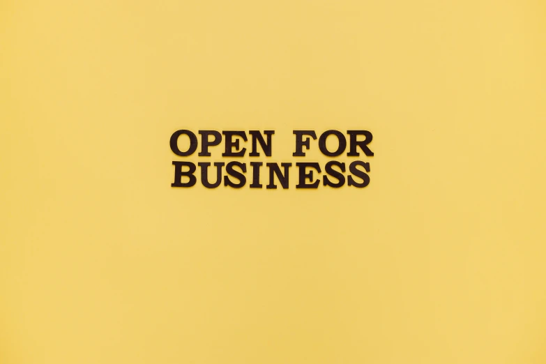 a sign that says open for business on a yellow background, an album cover, trending on unsplash, ffffound, in the style of john baldessari, seen from straight above, wes anderson movie