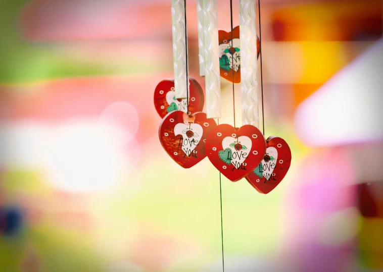 a couple of red hearts hanging from a string, a picture, by Julia Pishtar, pexels, folk art, wind chimes, colorful”, multiple stories, shot on sony alpha dslr-a300