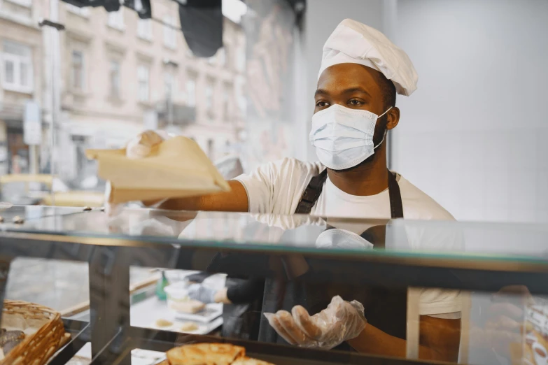 a man wearing a face mask behind a bakery counter, pexels contest winner, renaissance, black man, thumbnail, surgeon, lachlan bailey