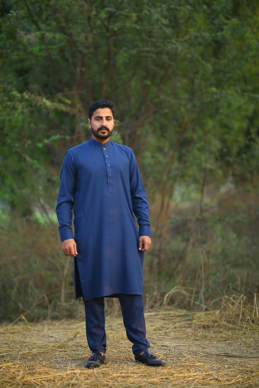 a man standing in the middle of a field, by Riza Abbasi, renaissance, navy blue, cotton, subtle detailing, multiple colors