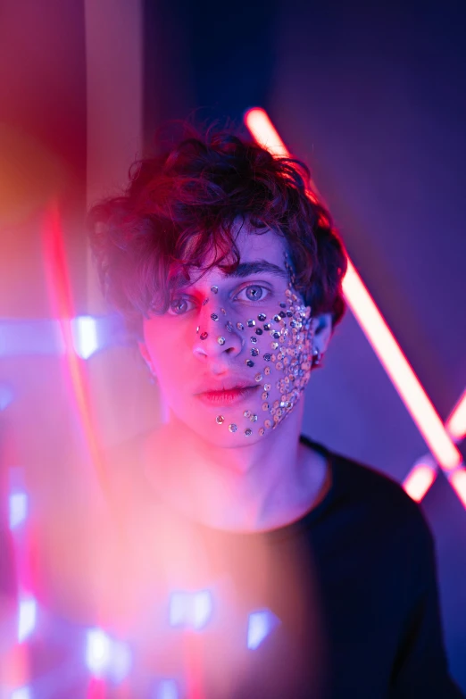 a man standing in front of neon lights, an album cover, pexels contest winner, holography, portrait of timothee chalamet, neon face paint, covered in circuitry, sophia lillis