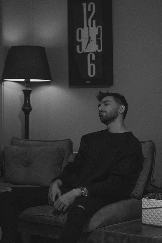 a man sitting in a chair in a living room, a black and white photo, charli bowater, artem, single subject, (night)