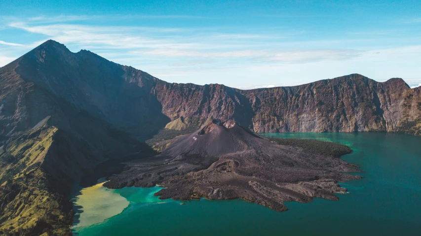 a large body of water surrounded by mountains, by Julia Pishtar, pexels contest winner, sumatraism, vulcano, blue and green water, black, scandinavian