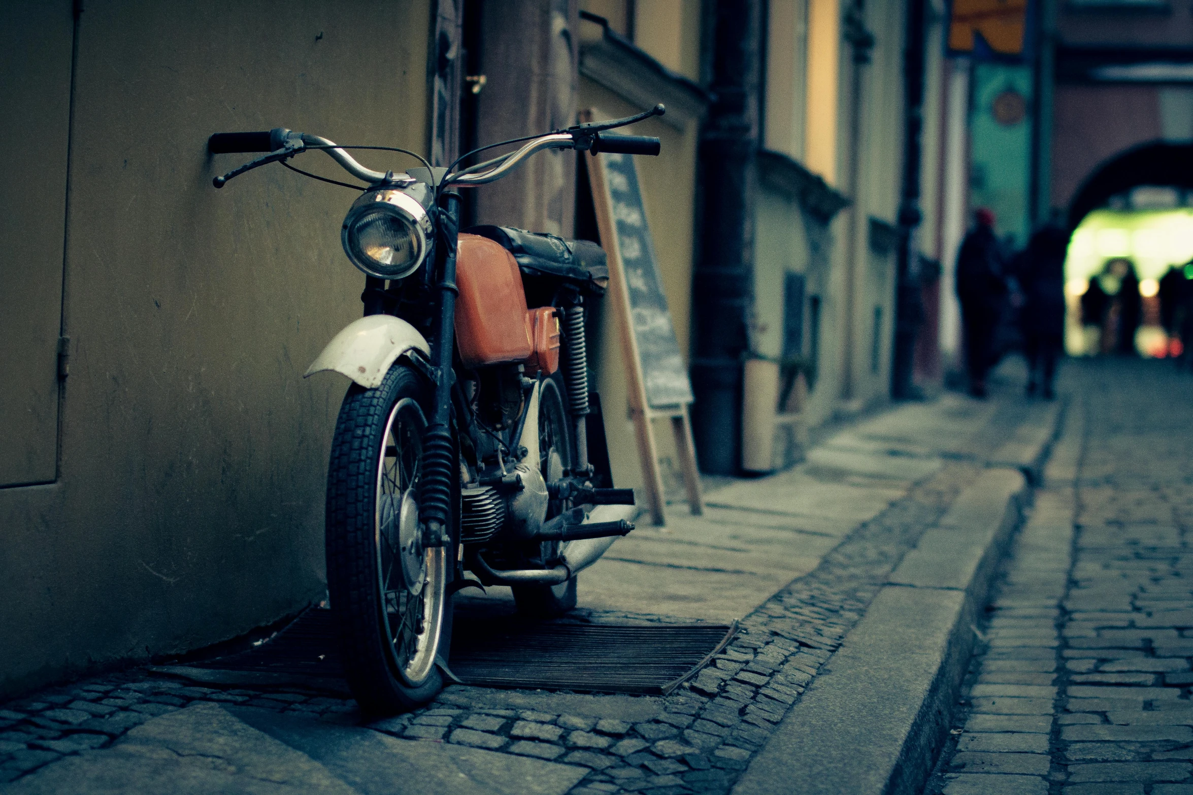 a motorcycle parked on the side of a street, by Adam Marczyński, historical, italian, close-up photograph, a small