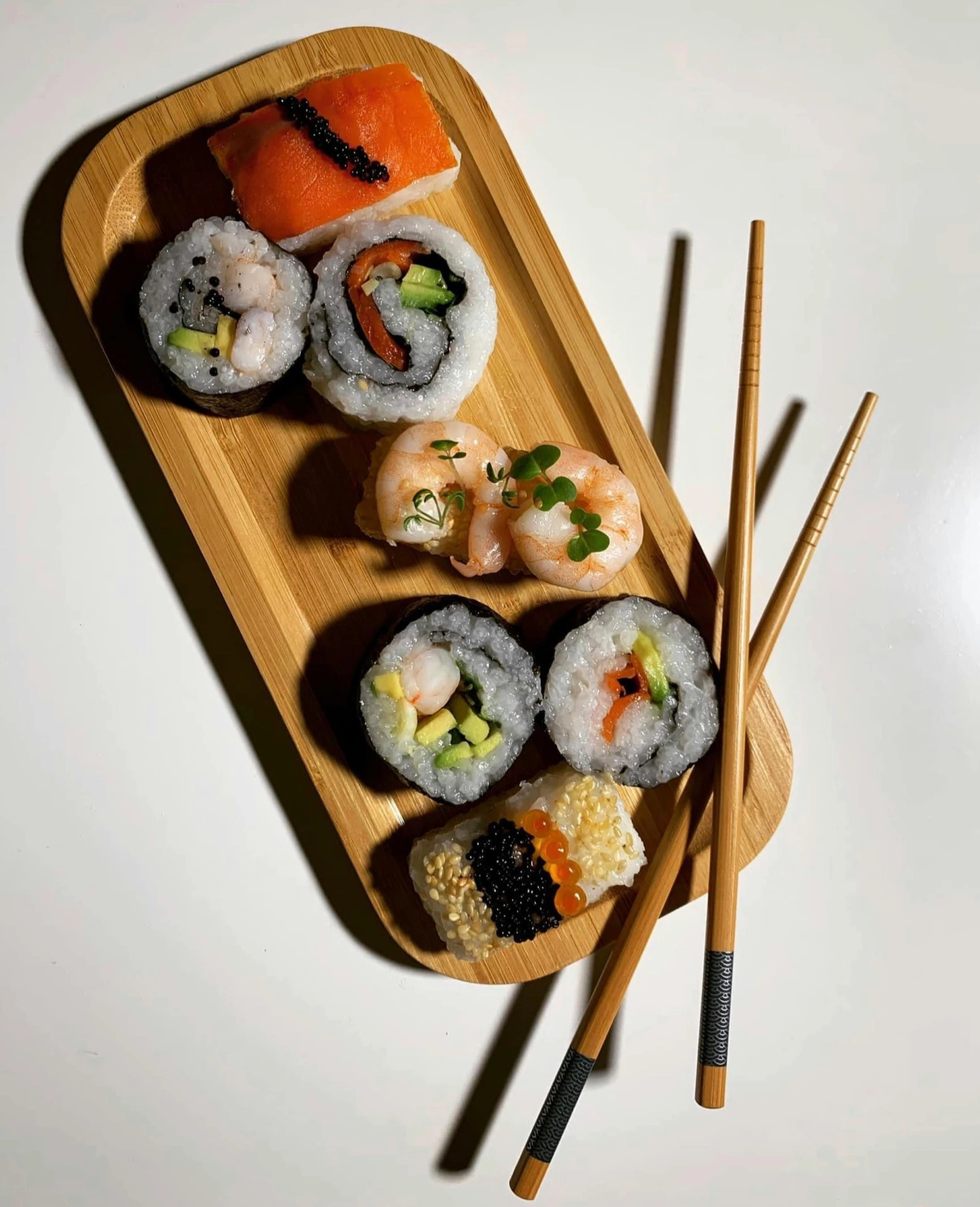 a wooden plate topped with sushi and chopsticks, photograph taken in 2 0 2 0, 🎀 🗡 🍓 🧚, snapchat photo, simon lee