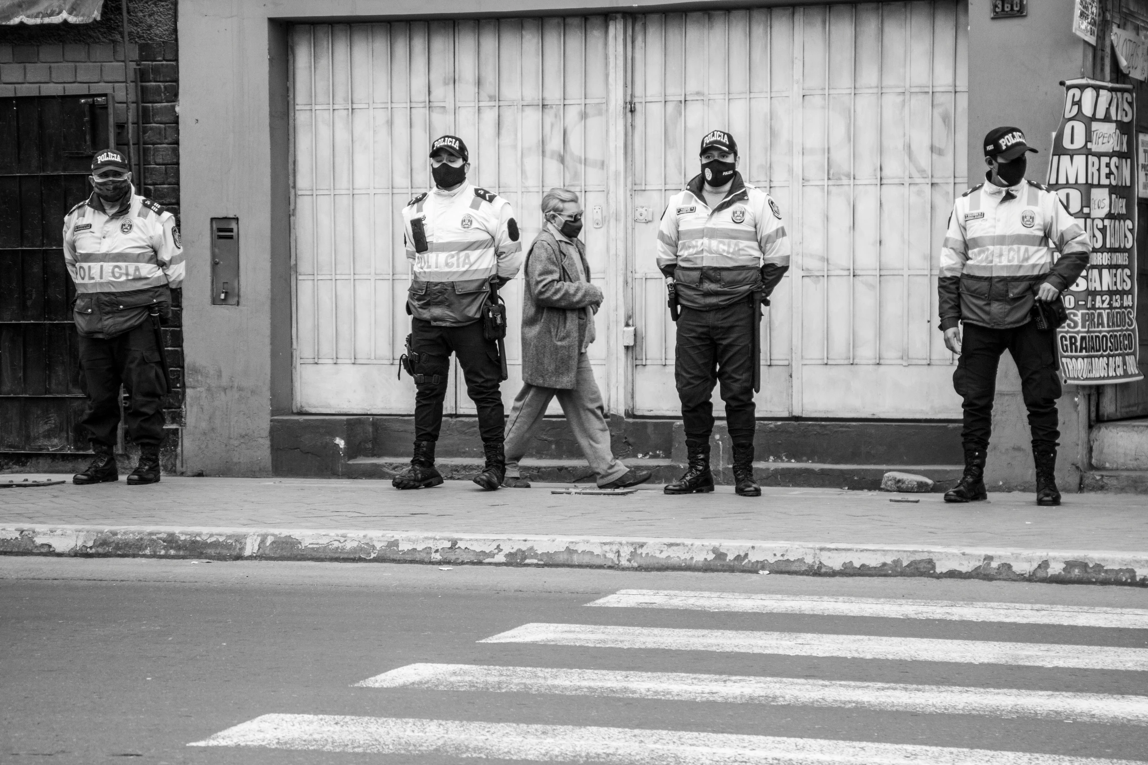 a group of police standing in front of a building, a black and white photo, by Luis Molinari, pexels, excessivism, buenos aires, traffic police woman, two men, old cmputers on the sidewalk