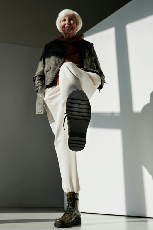 a man standing on top of a white floor next to a window, trending on pexels, gum rubber outsole, wearing cargo pants, wearing a turtleneck and jacket, white pants