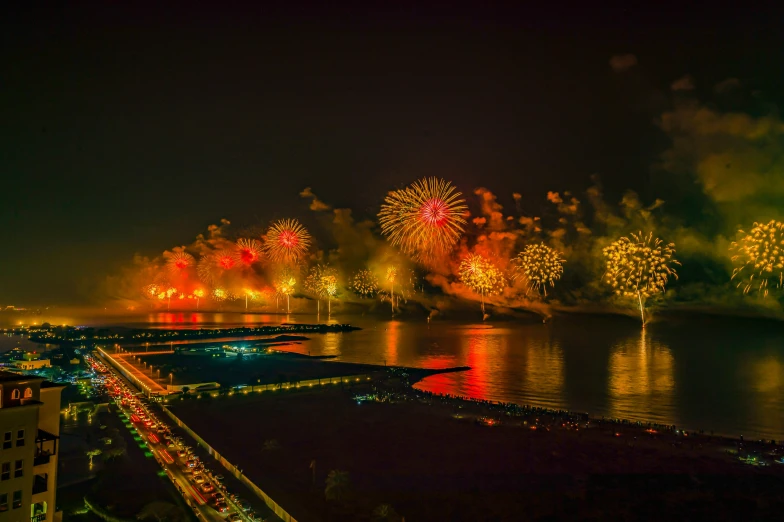 fireworks light up the night sky over a body of water, pexels contest winner, hurufiyya, oman, thumbnail, beeple. hyperrealism, carnaval de barranquilla