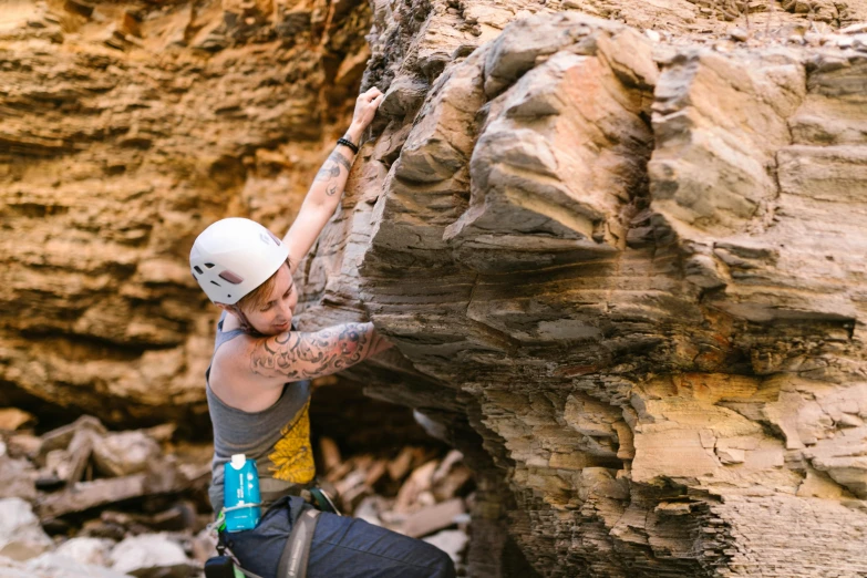 a man climbing up the side of a rock, a portrait, by Lee Loughridge, pexels contest winner, mid 2 0's female, sandstone, glassy fracture, avatar image