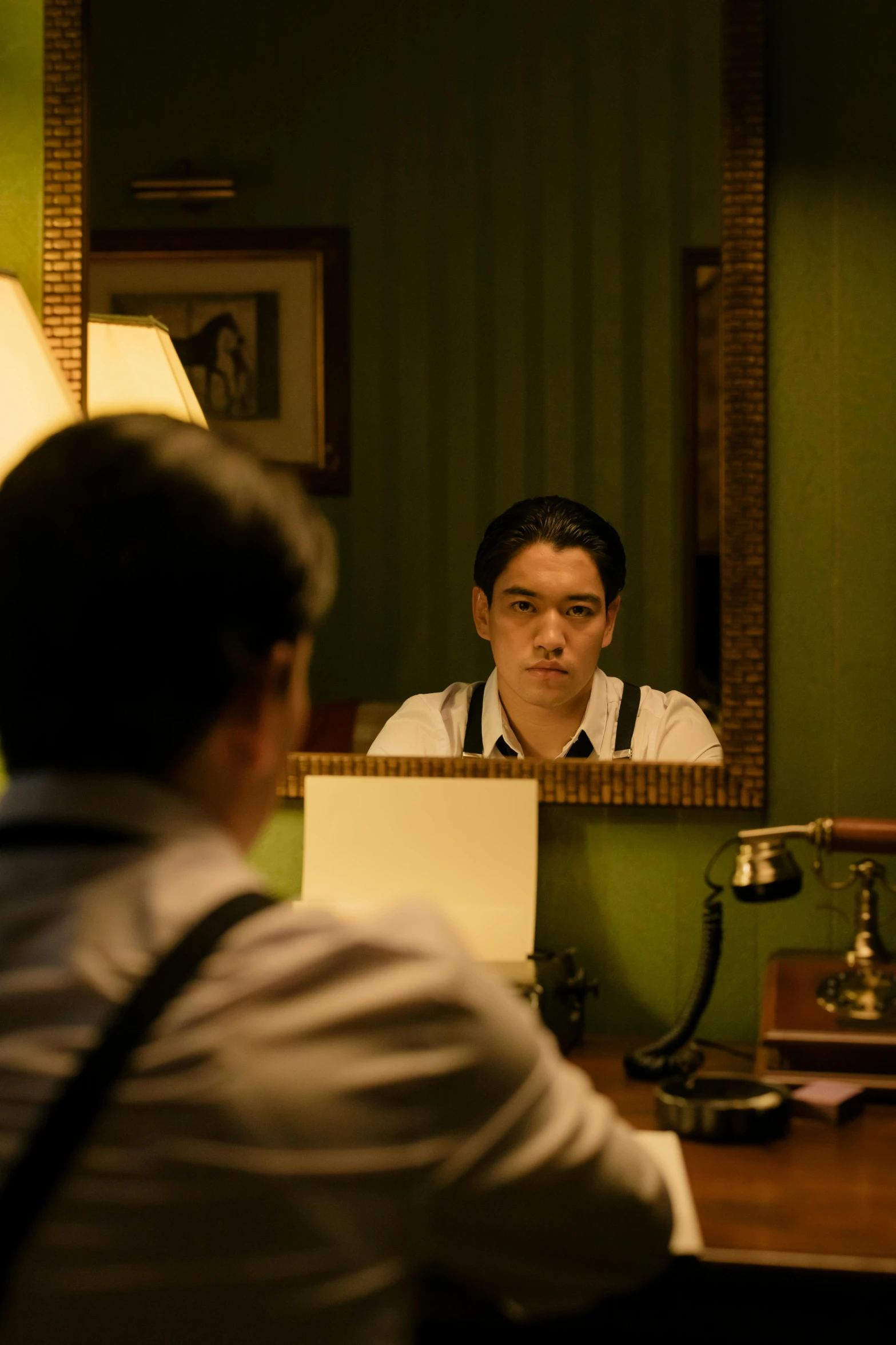 a man sitting at a desk in front of a mirror, inspired by Hideyuki Kikuchi, unbroken, [ theatrical ]
