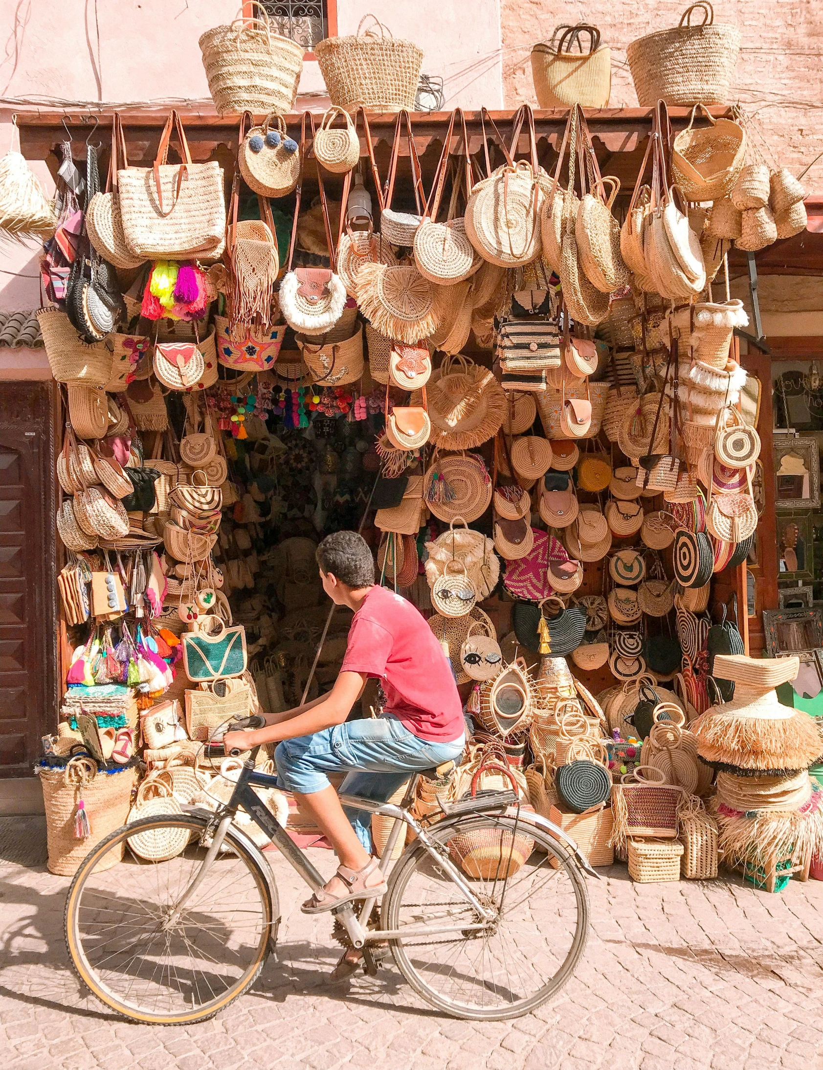 a person riding a bike in front of a store, crafts and souvenirs, 🚿🗝📝