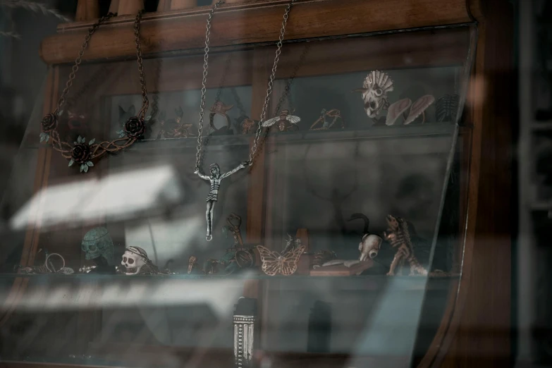 a reflection of a crucifix in a shop window, by Elsa Bleda, trending on pexels, assemblage, skeletons on a pirate ship, jewelry engraved in scarab, silver and muted colors, a magician's chamber