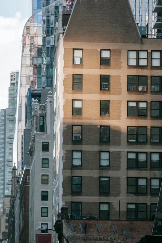 a city street filled with lots of tall buildings, a photo, unsplash contest winner, modernism, rundown new york apartment, side view from afar, golden windows, ignant