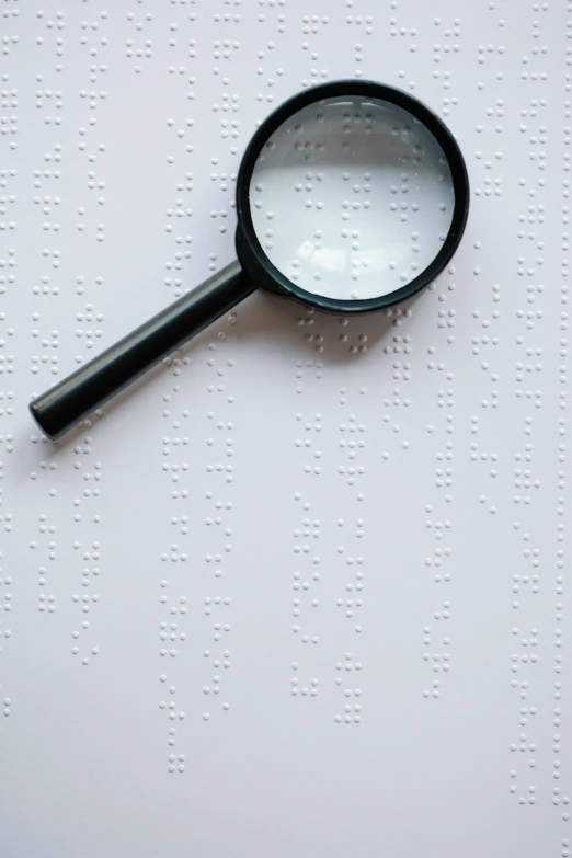 a magnifying glass sitting on top of a piece of paper, by Carey Morris, trending on pexels, ascii art, white freckles, embossed, bl, diagnostics