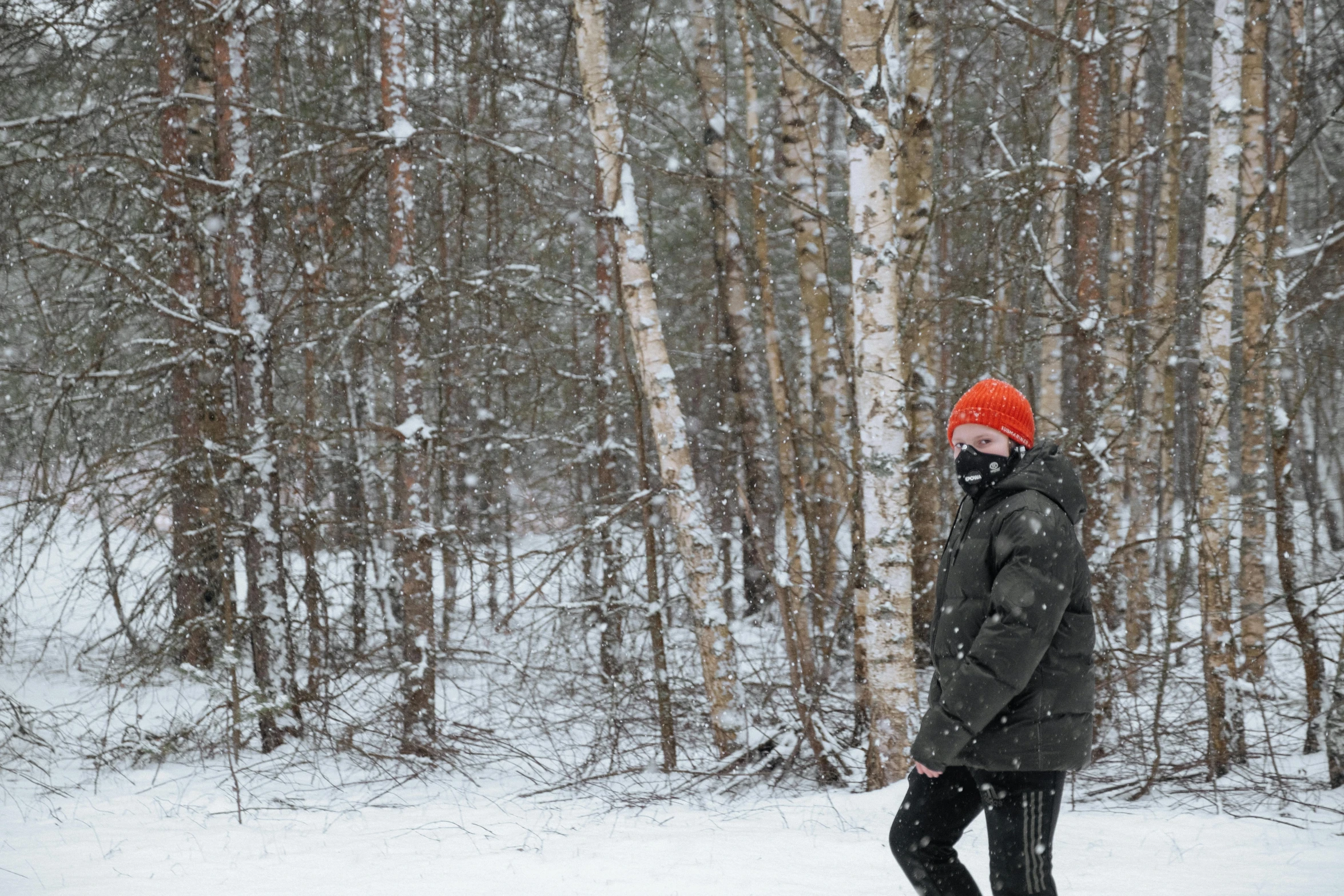 a man riding a snowboard down a snow covered slope, by Jaakko Mattila, pexels contest winner, visual art, girl walking in forest, with black beanie on head, (3 are winter, betula pendula