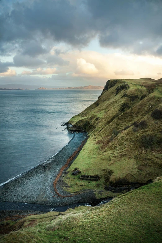 a large body of water sitting on top of a lush green hillside, a matte painting, by Alexander Robertson, pexels contest winner, coastal cliffs, skye meaker, shot at golden hour, conde nast traveler photo