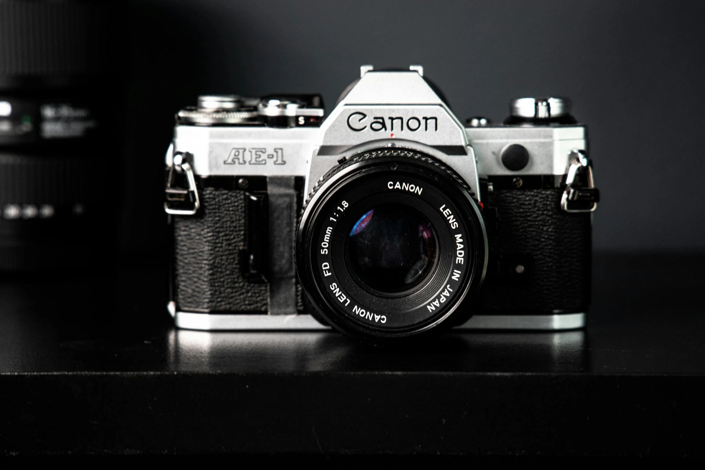 a camera sitting on top of a wooden table, a picture, canon a1, in front of a black background, thumbnail, cannon