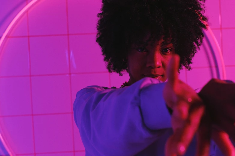 a woman pointing her finger at the camera, pexels contest winner, afrofuturism, pink violet light, still from movie, pretty samurai with afro, light from bottom