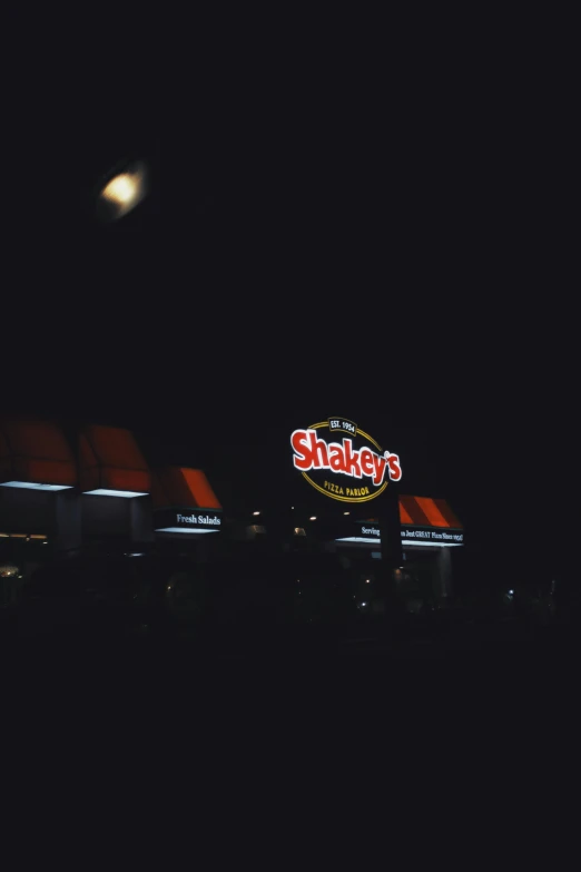 a fast food restaurant lit up at night, an album cover, by Harold Shapinsky, pexels, black sky, grainy picture, shaky, ✨🕌🌙