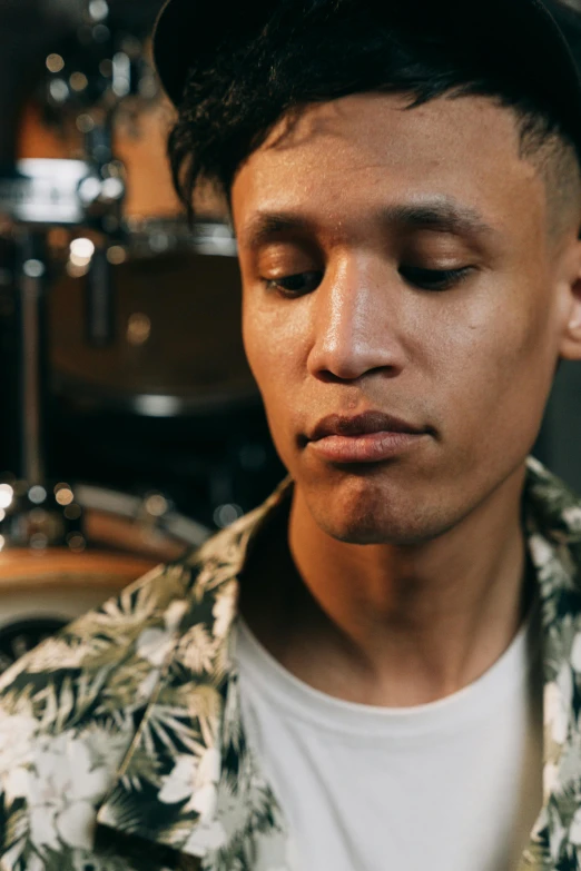 a man standing in front of a drum kit, an album cover, inspired by Byron Galvez, trending on pexels, sumatraism, masculine jawline, androgynous face, detailed expression, thoughtful