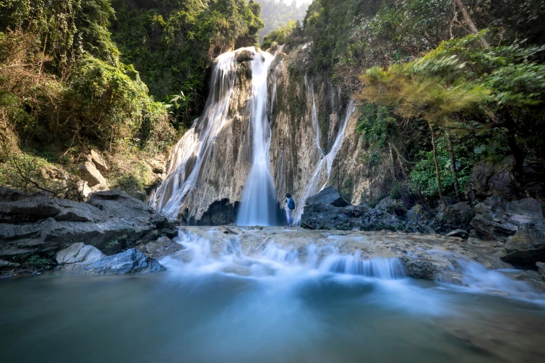 a man standing in front of a waterfall, by Peter Churcher, unsplash contest winner, sumatraism, slide show, abel tasman, ultrawide image, thumbnail