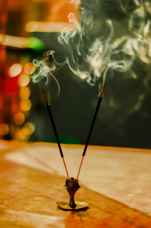 a incense stick sitting on top of a wooden table, smoke out of eyes, displayed on an altar, sparklers, hindu aesthetic