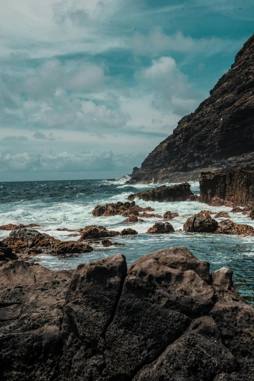 a man standing on top of a rock next to the ocean, pexels contest winner, process art, azores, rough waves, slide show, in the distance is a rocky hill