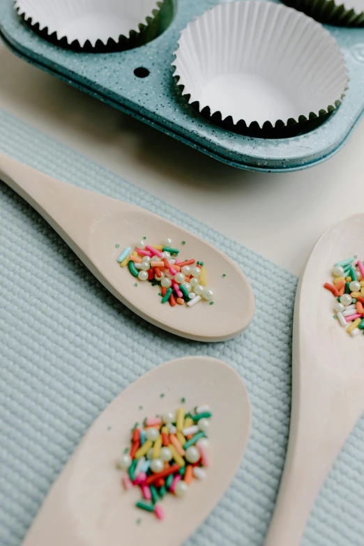 a couple of spoons that have sprinkles on them, sweeping, sustainable materials, baking a cake, cute details