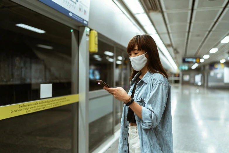 a woman with a face mask looking at her phone, pexels contest winner, underground facility, avatar image, woman holding sign, mrt