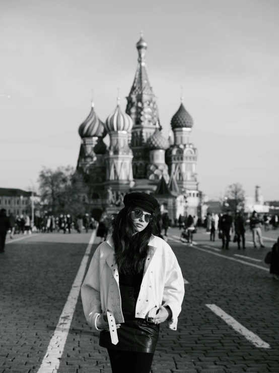 a black and white photo of a woman walking down a street, by Miroslava Sviridova, happening, red square, :: madison beer, wearing sunglasses and a hat, russian temple