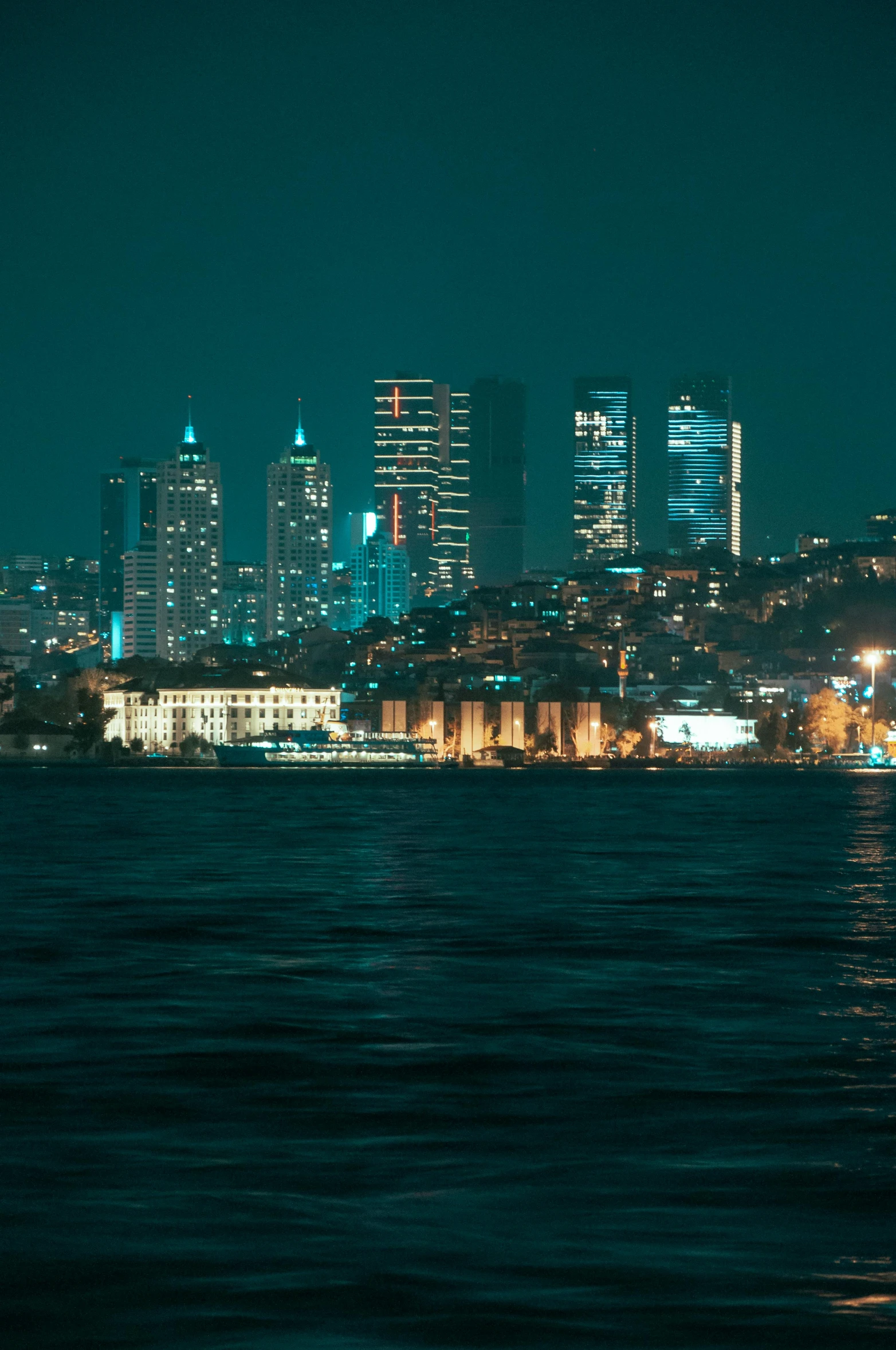 a large body of water with a city in the background, inspired by Elsa Bleda, pexels contest winner, turkey, night life buildings, viewed from the ocean, slide show