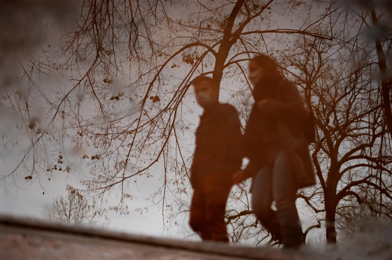 a reflection of two people in a puddle of water, a picture, by Béla Nagy Abodi, pexels contest winner, romanticism, under the soft shadow of a tree, medium format. soft light, brown, couple