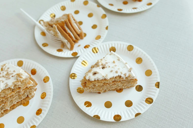 a close up of three plates of food on a table, cake, gold speckles, detailed product image, white with gold accents